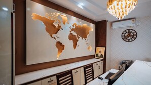 Un espacio de oficina moderno con un gran mapa mundial en la pared, una araña y un reloj.