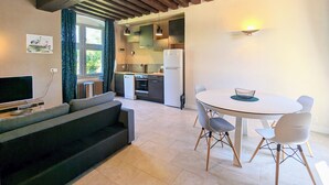 A modern kitchen with a dining area, built-in appliances, and a large window. - Historic 2BR Cottage with Modern Amenities & Shared Pond in Brenne Park (Communauté de communes Brenne - Val de Creuse-Douadic)