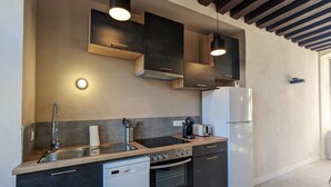 A modern kitchen with a dishwasher, oven, and a refrigerator. - Historic 2BR Cottage with Modern Amenities & Shared Pond in Brenne Park (Communauté de communes Brenne - Val de Creuse-Douadic)