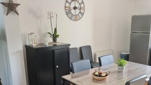 A modern kitchen with a wooden table, chairs, a clock, and a refrigerator. - THE HOLIDAYS (Arques)