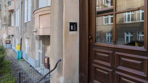 Une porte marron avec un panneau en verre, un petit clavier et une poignée en métal.
