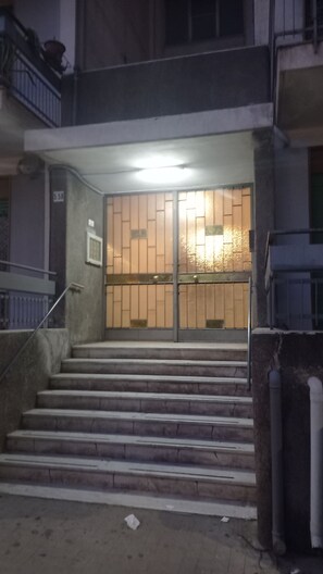 A building entrance with a metal gate, a staircase leading up, and a number '550' on the wall. - New Dawn Apartment, Free Parking, near IKEA, Siciliafiera, and Primark ct (Catania)