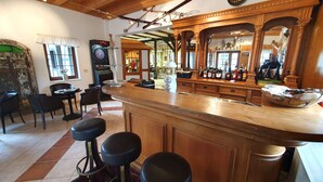 A bar area with stools, a dartboard, and a mirror reflecting the room. - Hotel Seiffener Hof (Seiffen)