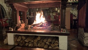 Een haard met brandhout, omringd door verschillende voorwerpen en decoraties.