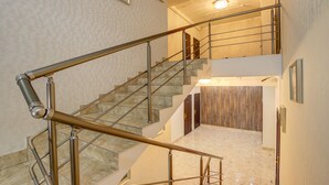 A multi-level interior with a staircase, marble flooring, and wooden paneling. - Hotel Touristan Bishkek (Bishkek)