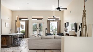 A spacious living area with a sofa, a kitchen island, and a dining area. - Private Desert Sanctuary with Pool, Spa, & Putting Green (Cave Creek)