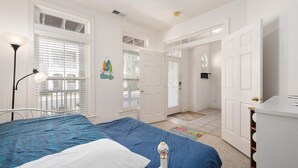 Un dormitorio con cama, mesita de noche, lámpara y cómoda.