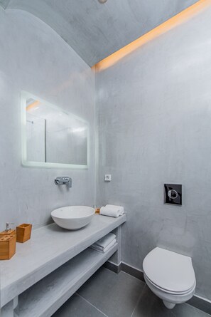 Een moderne badkamer met een grote spiegel, een wit wastafelmeubel en een toilet.