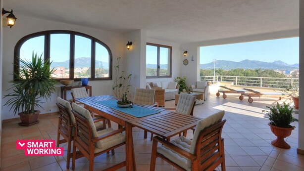 Une pièce spacieuse comprenant un coin repas, un canapé et un balcon offrant une vue sur les montagnes.