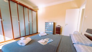 Ein Schlafzimmer mit einem Bett, einem Kleiderschrank und einem kleinen Schrank.