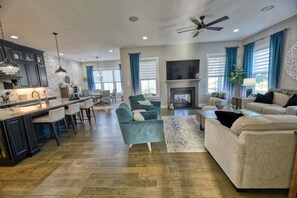 A spacious living area with a kitchen, a fireplace, and a dining area. - Coastal Club * 18353 * NEW Exceptional Lewes Beach House (Lewes)