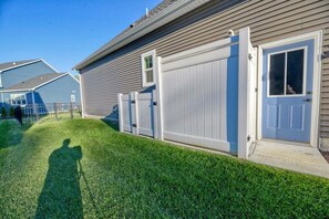 A residential house with a well-maintained lawn, a garage door, and a visible shadow of a person. - Coastal Club * 18353 * NEW Exceptional Lewes Beach House (Lewes)
