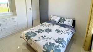 Un dormitorio moderno con una cama grande, un armario y una puerta.