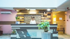 A reception desk with a receptionist, a 'No Smoking' sign, and a 'Silence Please' sign. - Hotel Saptarshi (Bankura)