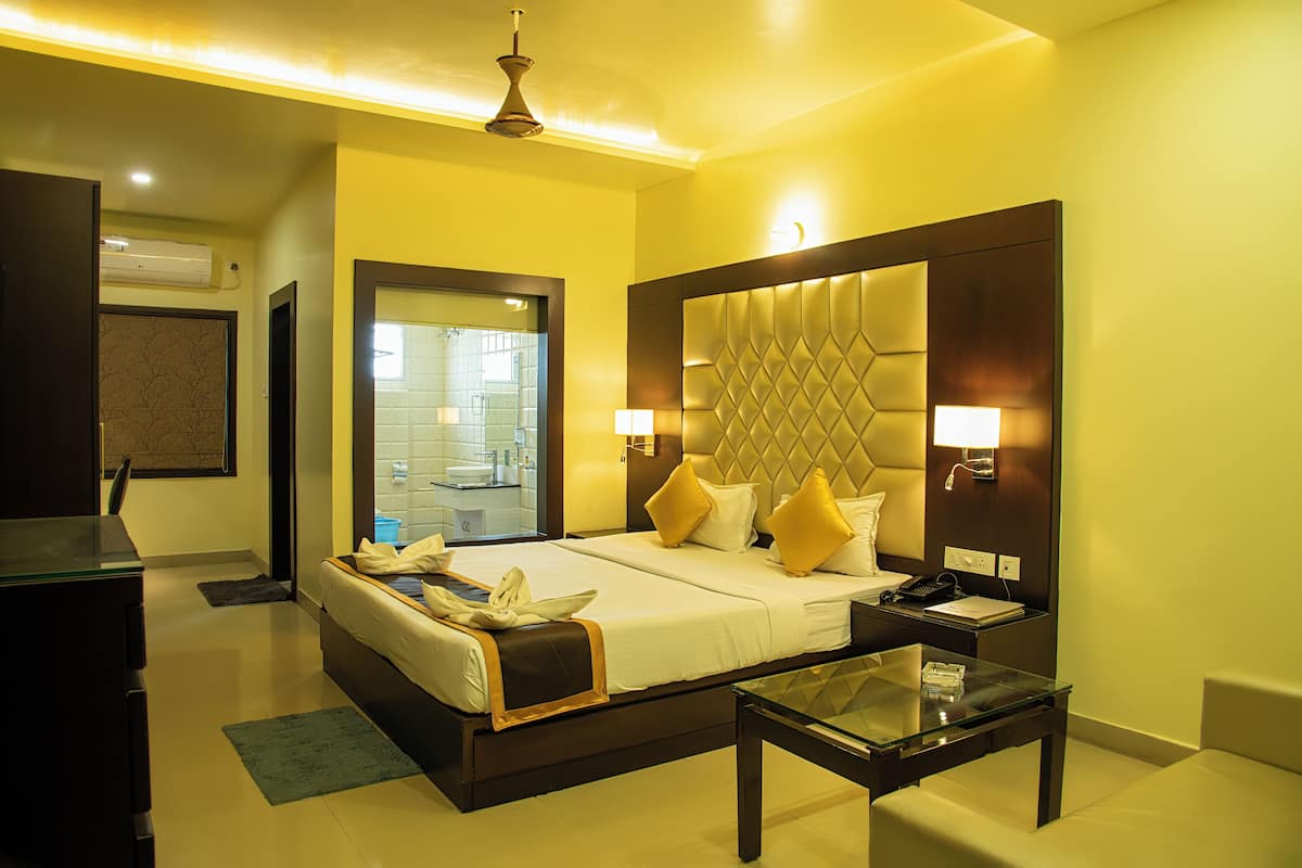 A hotel room with a bed, bedside table, and a glass coffee table.