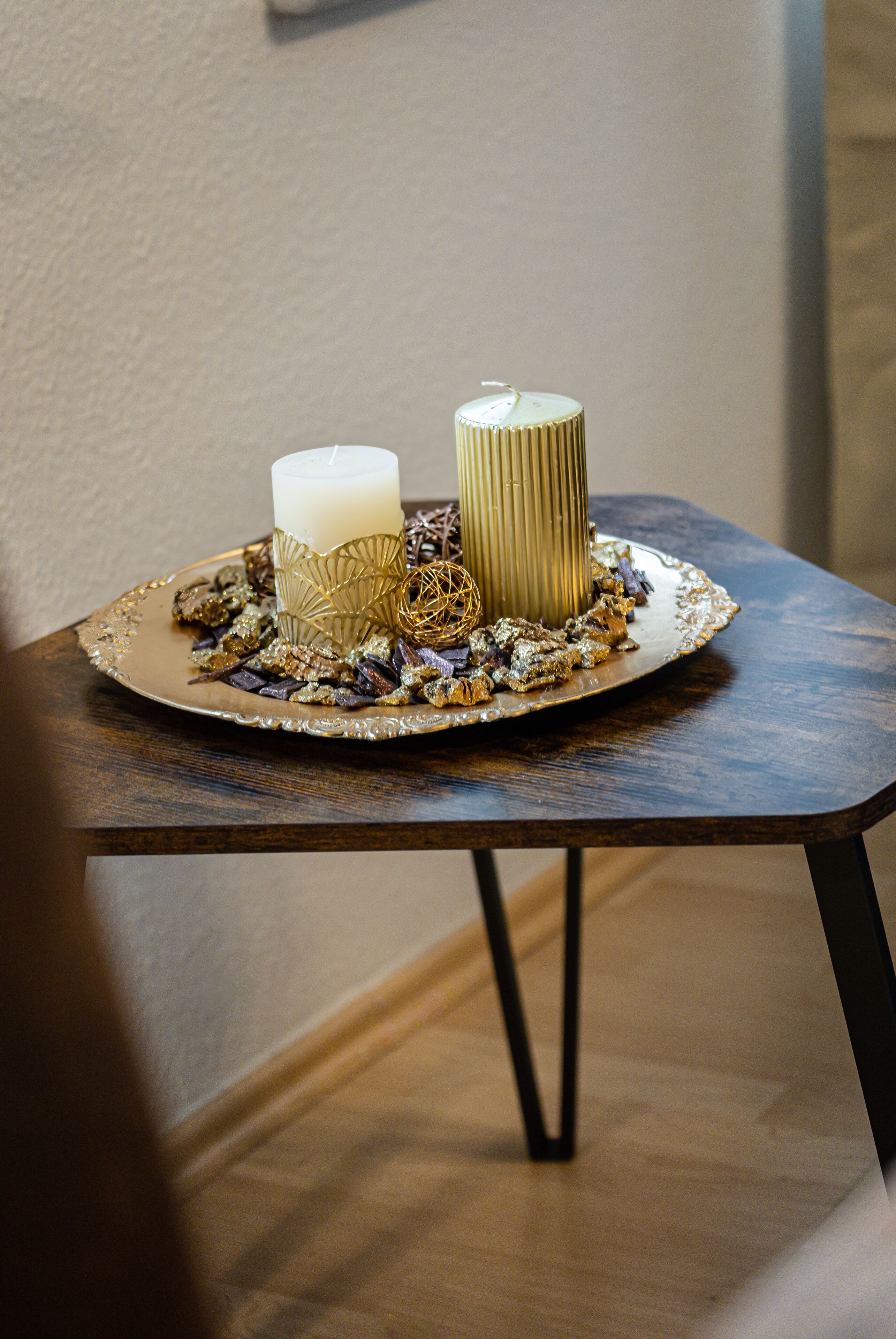 A table with a candle and decorative items on a tray.