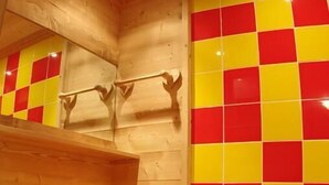 A wooden bathroom with a checkered tile wall, a wooden vanity, and a bathtub. - 100m from ski slopes, 4th floor, view mountain, tv, ski locker, 61m², Valmorel (Valmorel)