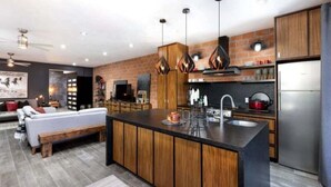 Una cucina moderna con isola centrale, mobili in legno e illuminazione a sospensione.