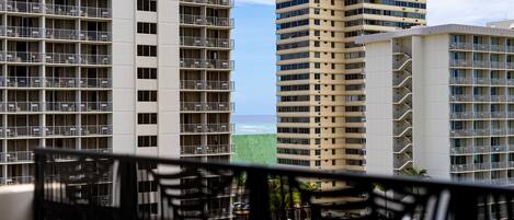 Ein Hochhaus-Hotel mit mehreren Balkonen, einem Poolbereich und Blick auf das Meer.