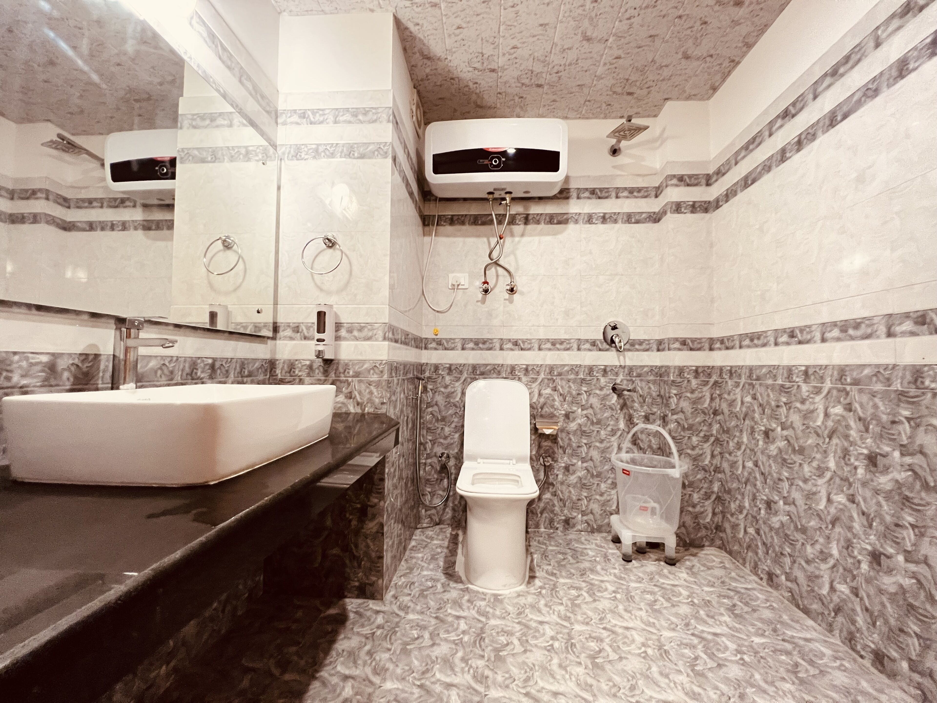 Une salle de bain avec un lavabo, des toilettes et une douche, le tout de couleur blanche.