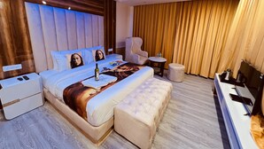 Un dormitorio moderno con una cama grande, una zona de estar y un tocador.