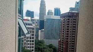 A high-rise building with a modern design, featuring a prominent tower and multiple glass facades.