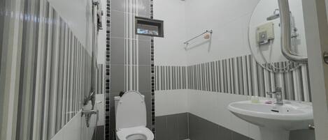Un baño moderno con inodoro, ducha y lavabo.