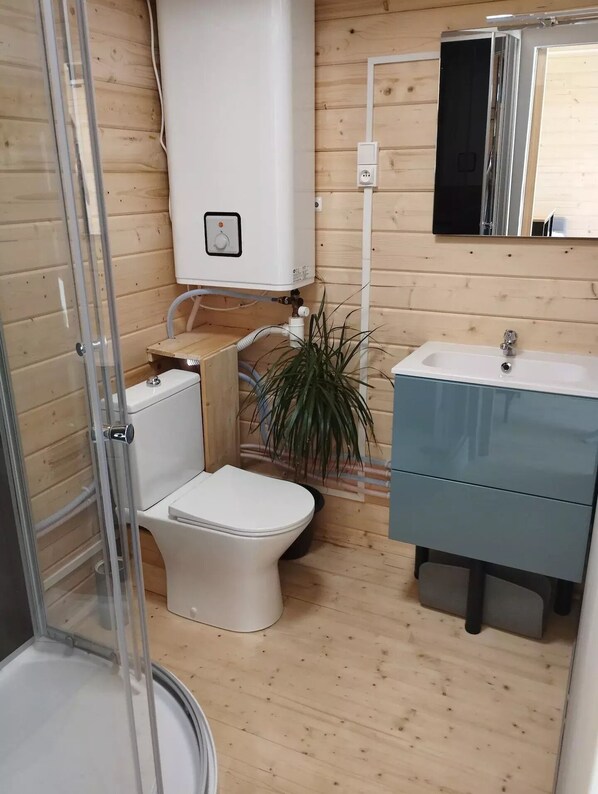 Ein kleines Badezimmer mit Toilette, Waschbecken und Duschkabine.