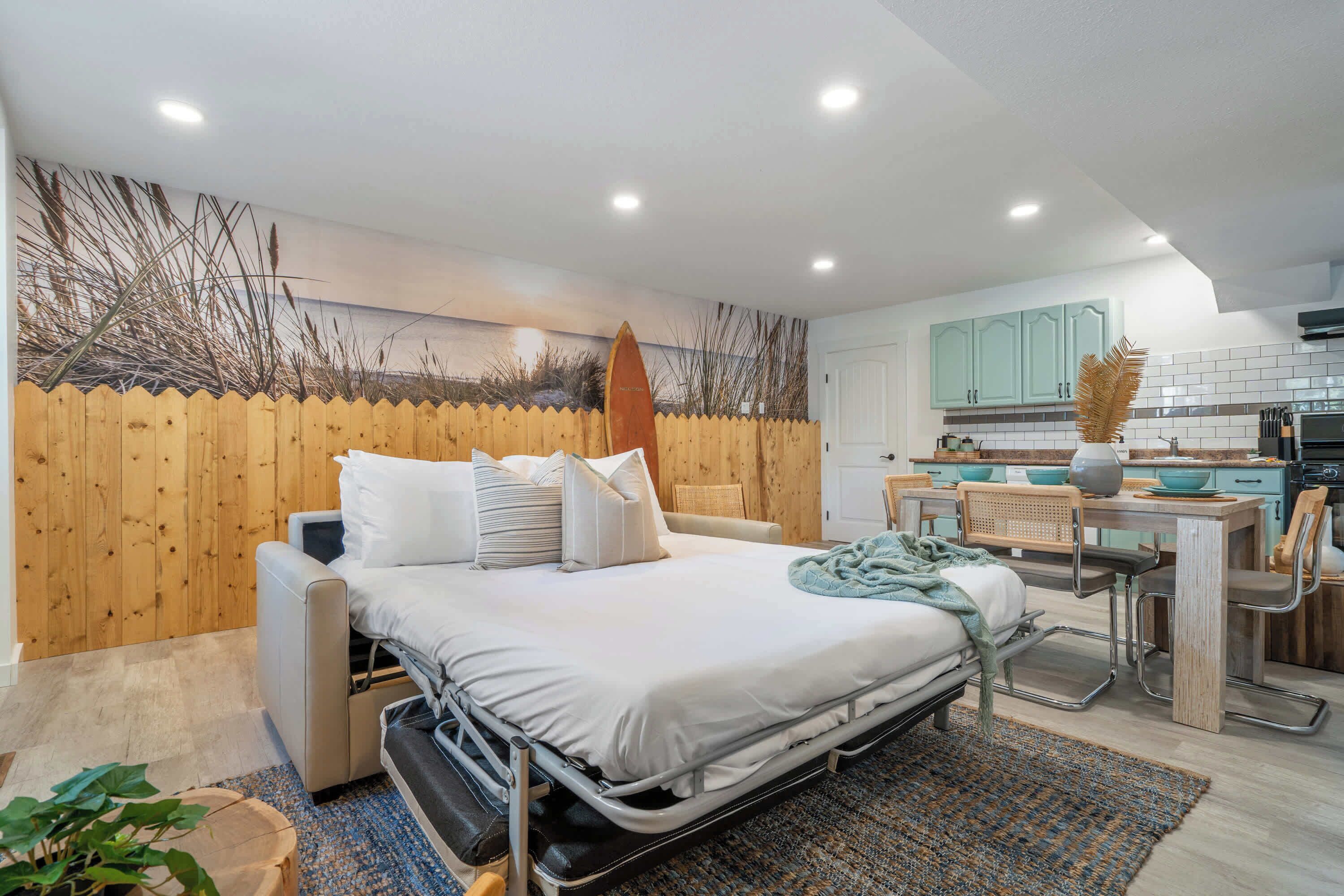 A compact bedroom with a bed, bedside table, and a small kitchenette area.
