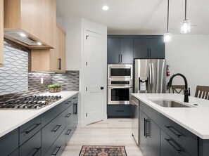 Enjoy cooking in this well-equipped kitchen with a central island, oven, and ample storage.