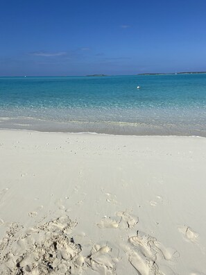 A beach with clear turquoise water and white sand.