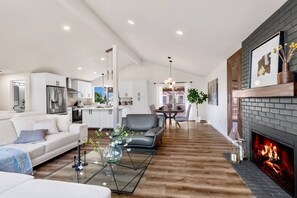 Relax in a cozy living space with a fireplace, comfortable seating, and a functional kitchen.