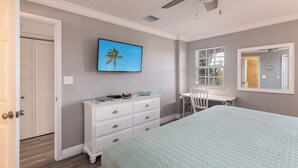 A bedroom with a bed, a dresser, a desk, and a TV on the wall. - Sea View and Sunrise Ocean Pointe 2412 2BA/2BR (Tavernier)