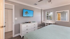 A bedroom with a bed, a dresser, a desk, and a TV on the wall. - Sea View and Sunrise Ocean Pointe 2412 2BA/2BR (Tavernier)
