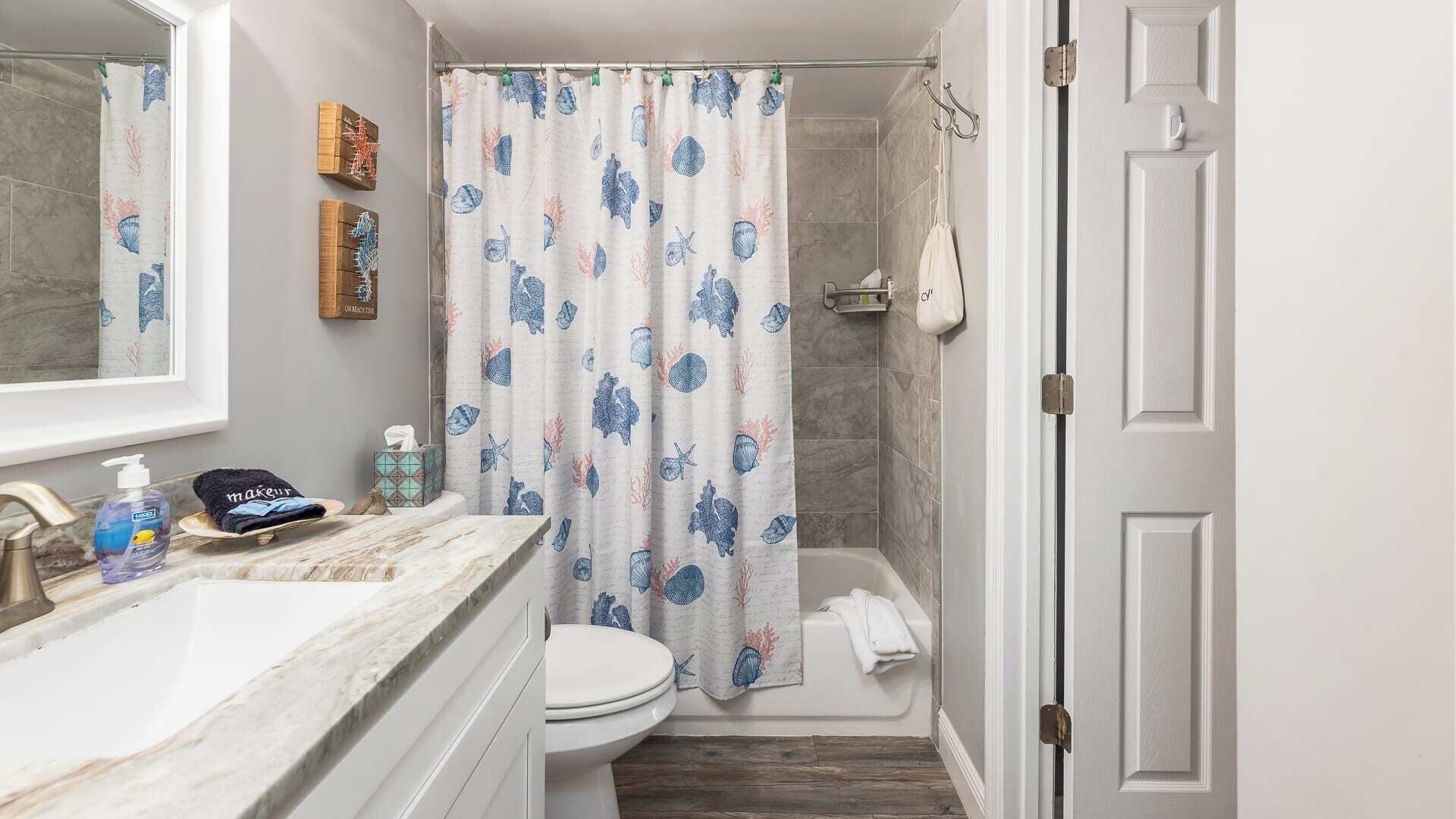A bathroom with a shower, toilet, and sink.