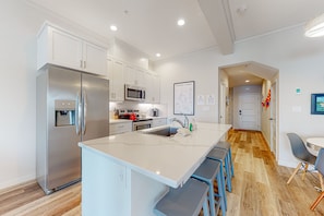 Enjoy cooking in this well-lit kitchen with a large island, sink, and bar seating.