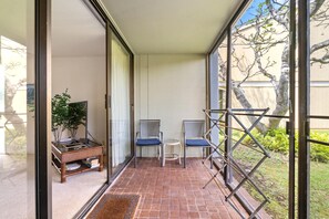 Ein Balkon mit zwei Stühlen, einem kleinen Tisch und einem Blumentopf.
