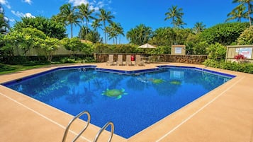 Ein rechteckiger Pool mit klarem, blauem Wasser, umgeben von einer beigen Liegefläche.
