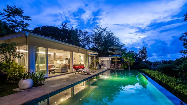 A modern house with a swimming pool, outdoor seating, and a well-lit interior. - Luxury 3BR Kahuripan Villa (Bali)