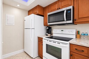 Una cocina equipada con refrigerador, microondas, estufa y horno.