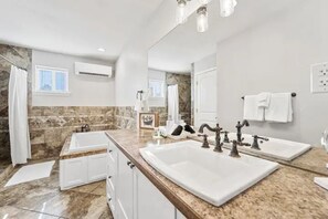 A modern bathroom with a double sink, a bathtub, and a shower. - Serene Stay w/ Mountain Views in Downtown Monument (Monument)