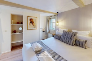 Relax in a stylish room with a large bed, bedside table, and wall-mounted shelf.