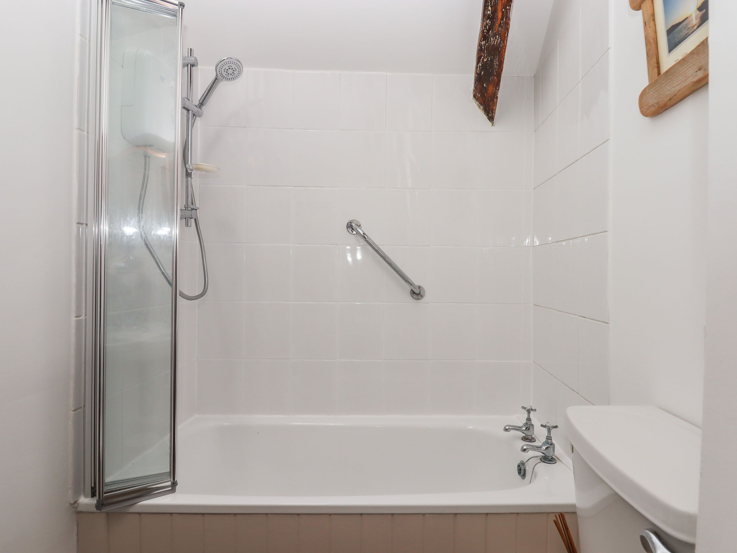 A bathroom with a glass-enclosed shower, a bathtub, and a sink.