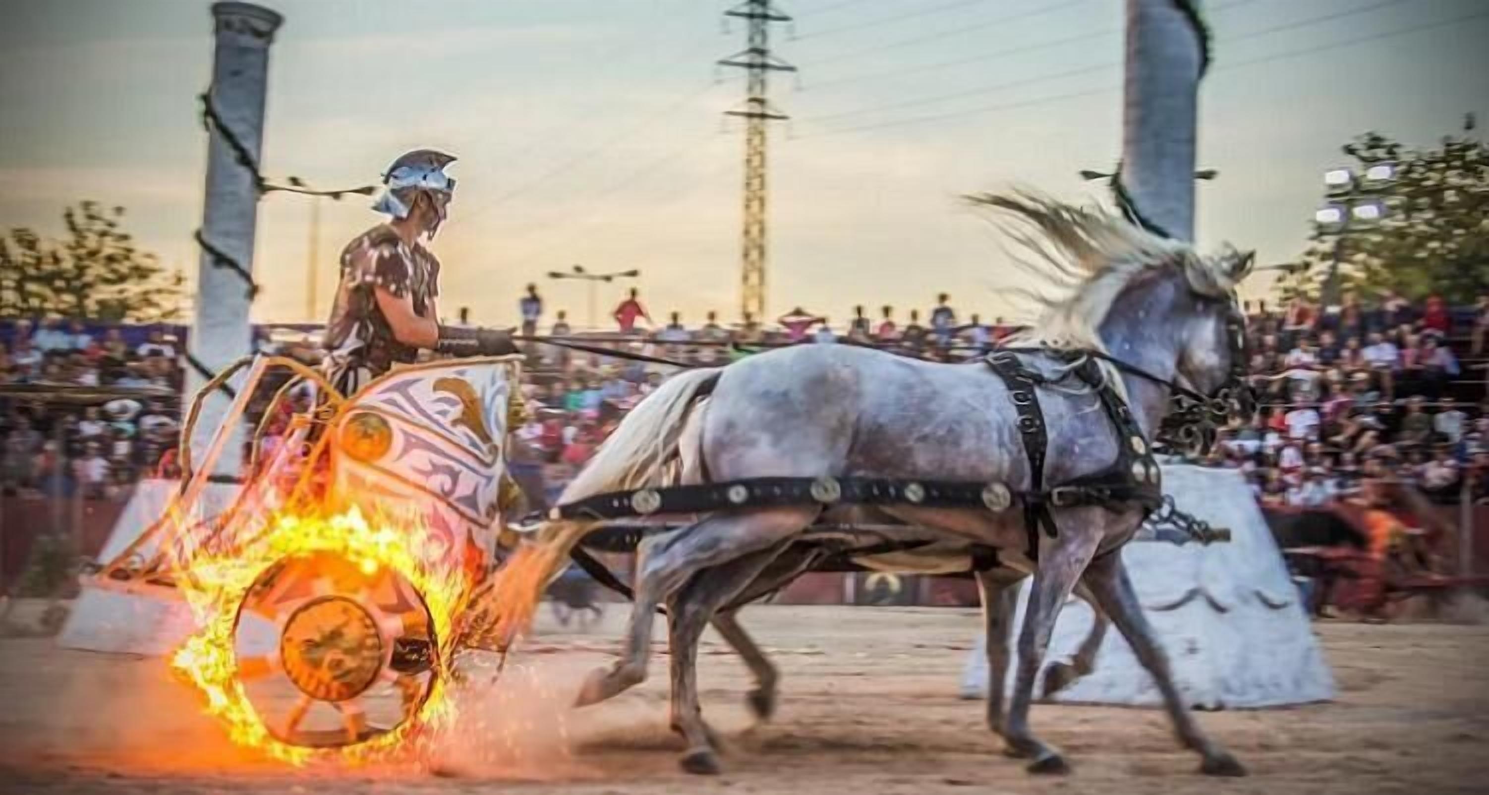 Una persona montando en un carruaje tirado por caballos con una rueda en llamas.