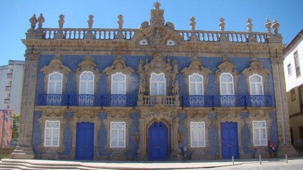 Un edificio histórico con fachadas de azulejos azules ornamentales, varios balcones y un elemento decorativo central.