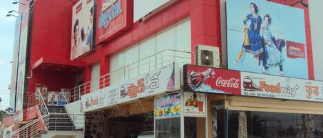 A multi-story building with various commercial establishments including a food court, a Coca-Cola outlet, and a Reliance Digital advertisement.