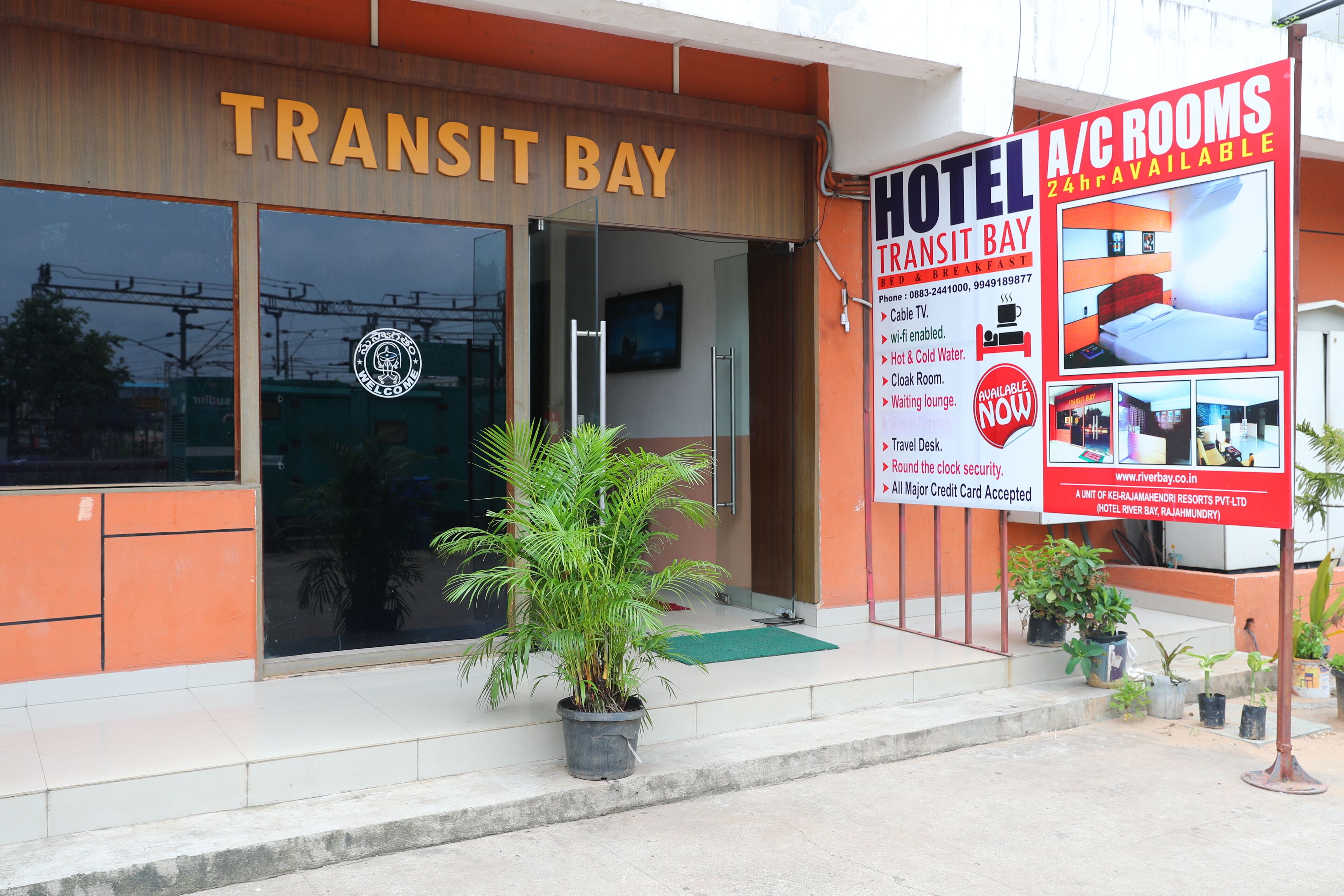 Een hotel genaamd Transit Bay met een bord waarop reclame wordt gemaakt voor kamers met airconditioning.