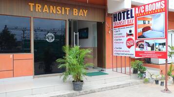 Een hotel genaamd Transit Bay met een bord waarop reclame wordt gemaakt voor kamers met airconditioning.
