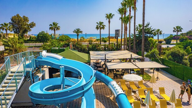 A water slide, outdoor seating, and a view of the ocean.