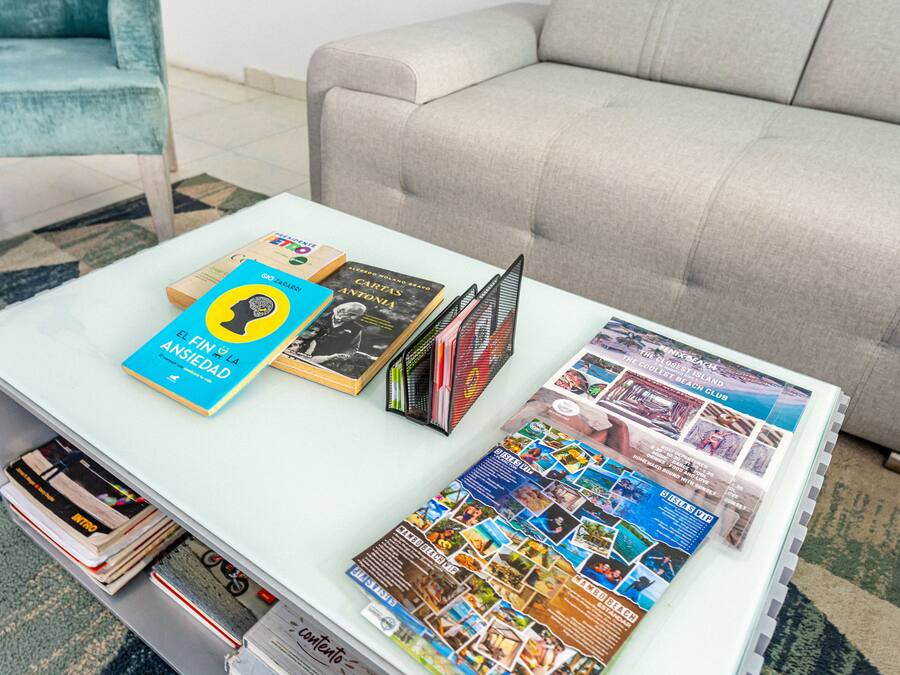 Ein Wohnzimmer mit Couchtisch, auf dem Bücher und Zeitschriften liegen.